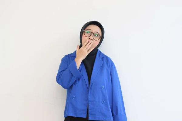 美しい若いアジア系イスラム教徒の女性 白い背景に隔離された口をカバーしながらショックを受けた表情で眼鏡と青いブレザーを身に着けています — ストック写真