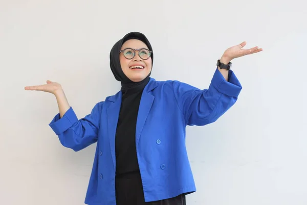 ヒジャーブ 青いブレザーを身に着けている美しい若いアジアのイスラム教徒の女性は自信を持って笑顔と白の背景に隔離された上を指して両手で幸せ 広告コンセプト — ストック写真