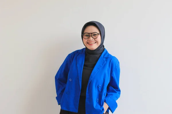若い美しいアジア系イスラム教徒の女性 白い背景に隔離された幸せな笑顔の表情を持つ眼鏡と青のブレザーを身に着けています — ストック写真