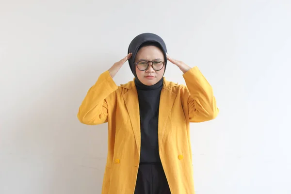 年轻美丽的亚洲穆斯林妇女 戴着眼镜 身穿黄色夹克 头戴白色背景的头罩 表现出紧张的姿势 广告概念 — 图库照片