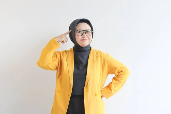 Красивая Молодая Азиатская Мусульманка Очках Жёлтом Пиджаке Думает Улыбаясь Изолированно — стоковое фото