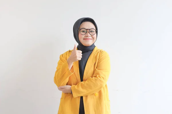 美丽的年轻的亚洲穆斯林妇女 戴着眼镜和黄色的夹克 手握认可的手势或可以独立的白色背景 — 图库照片