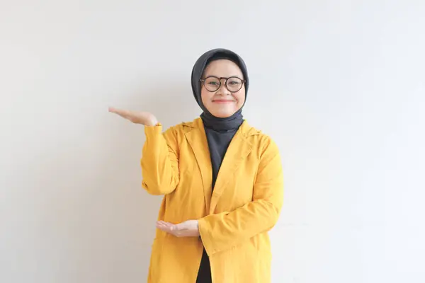 Красивая Молодая Азиатская Мусульманка Очках Жёлтом Пиджаке Показывающая Ладони Улыбаясь — стоковое фото