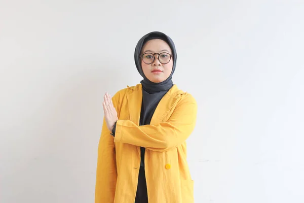 美丽的年轻的亚洲穆斯林妇女 戴着眼镜和黄色的夹克 表现出停止的姿态 而直率的面部表情则是孤立的白色背景 广告概念 — 图库照片