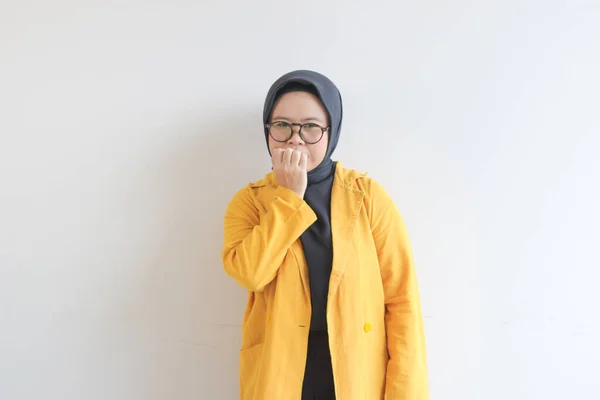 年轻美丽的亚洲穆斯林妇女 戴着眼镜 身穿黄色夹克 脸上带着恐惧的表情 背景是白色的 — 图库照片