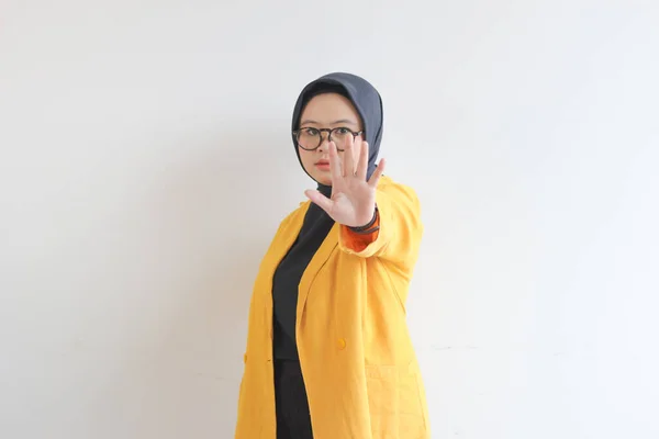 美しい若いアジアのイスラム教徒の女性は 眼鏡を着用し 黄色のブレザーを停止ジェスチャー孤立した白い背景を示しています 広告コンセプト — ストック写真