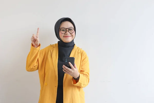 Красивая Молодая Азиатка Очках Хиджабе Жёлтом Пиджаке Держит Мобильный Телефон — стоковое фото