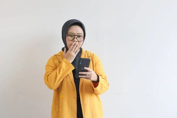 Gözlüklü Tesettürlü Sarı Ceketli Cep Telefonuna Bakan Beyaz Arka Planda — Stok fotoğraf