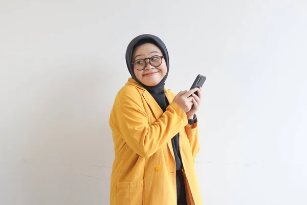 배경에 고립된 휴대폰을 웃으면서 안경을 노란색블라 아름다운 아시아인 이슬람 — 스톡 사진