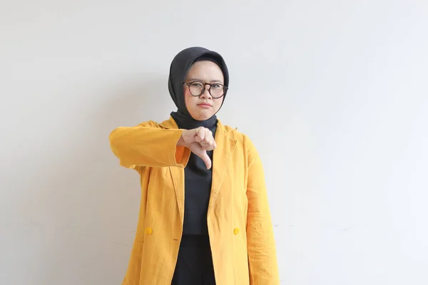 年轻美丽的亚洲穆斯林妇女 戴着眼镜 头戴黄色的夹克 手和脸都在摆着姿势 轻描淡写些什么 或者在白色背景下被孤立了 让人很失望 — 图库照片