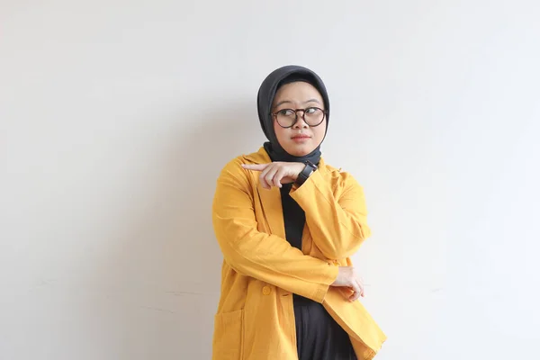 ヒジャーブ 黄色のブレザーを身に着けている美しい若いアジアのイスラム教徒の女性は自信と幸せと手を指して横に白い背景に孤立し 広告コンセプト — ストック写真