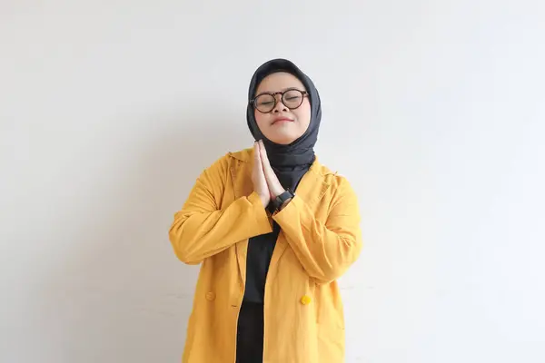 白い背景に隔離された目を閉じながら 幸せな笑顔の表情で眼鏡と黄色のブレザーを身に着けている若い美しいアジアのイスラム教徒の女性 — ストック写真