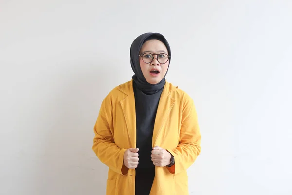 年轻美丽的亚洲穆斯林妇女 戴着眼镜和黄色的夹克 脸上带着震惊的表情 与白色背景隔离 — 图库照片
