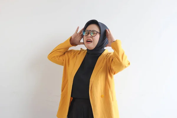 年轻美丽的亚洲穆斯林妇女 戴着眼镜 身穿黄色夹克 头戴白色背景的头罩 表现出紧张的姿势 广告概念 — 图库照片