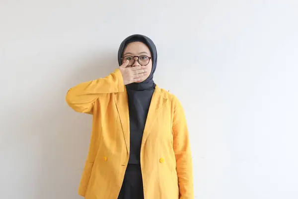 年轻美丽的亚洲穆斯林妇女 戴着眼镜 身穿黄色夹克 嘴紧闭 背景为白色 — 图库照片