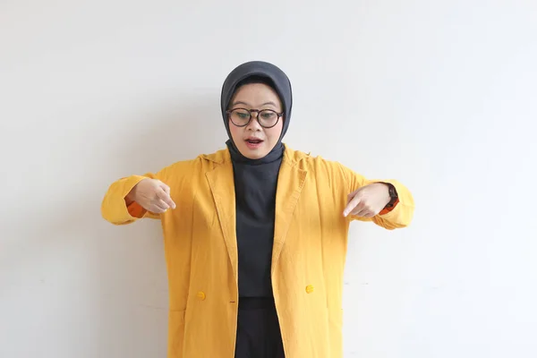 ヒジャーブ 黄色のブレザーを身に着けている美しい若いアジアのイスラム教徒の女性は自信を持って笑顔と白の背景に隔離された下を指す両手で幸せ 広告コンセプト — ストック写真