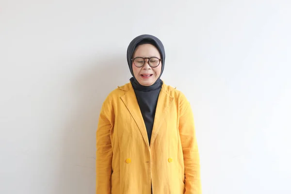 美しい若いアジア系イスラム教徒の女性 白い背景に隔離された悲しい表情で眼鏡と黄色のブレザーを身に着けています — ストック写真