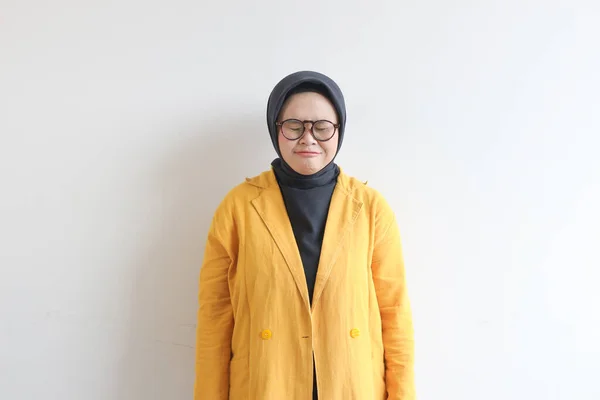 年轻美丽的亚洲穆斯林妇女 戴着眼镜 身穿黄色夹克 愁眉苦脸 与白色背景隔离 — 图库照片