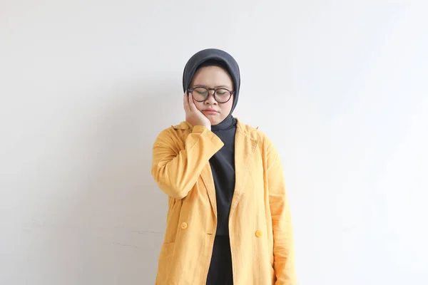 若い美しいアジア系イスラム教徒の女性 白い背景に隔離された歯痛のために悲しい表情の眼鏡と黄色のブレザーを身に着けています — ストック写真