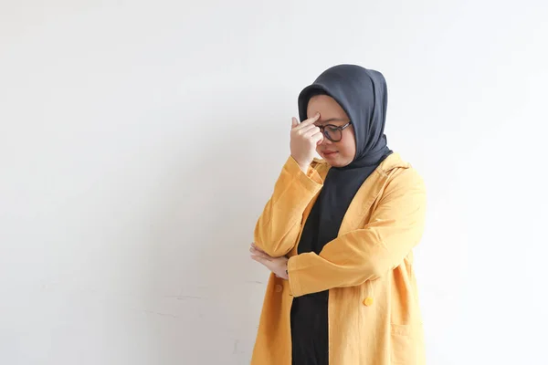 美しい若いアジア系イスラム教徒の女性 眼鏡をかけ 白い背景に隔離された頭を保持めまい式の黄色いブレザーを身に着けています — ストック写真