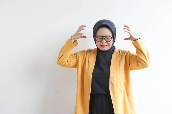 美しい若いアジアのイスラム教徒の女性は 白い背景に隔離されたストレスジェスチャーを示す眼鏡と黄色のブレザーを身に着けている 広告コンセプト — ストック写真