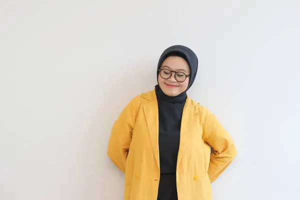 年轻美丽的亚洲穆斯林妇女 戴着眼镜 穿着黄色的夹克 面带微笑地仰视着被白色背景隔开的侧面 — 图库照片