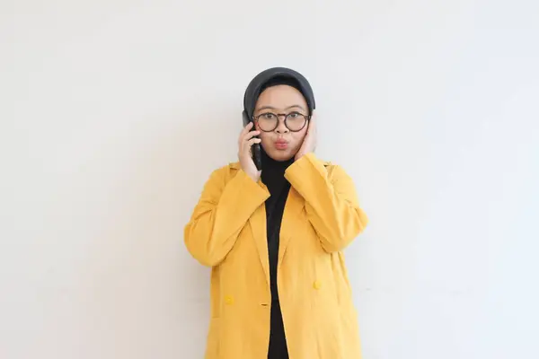 美しいアジアの女性の肖像画でヒジャーブ 眼鏡とかわいい顔の表情で電話を作る黄色のブレザーを身に着けています孤立した白い背景 — ストック写真