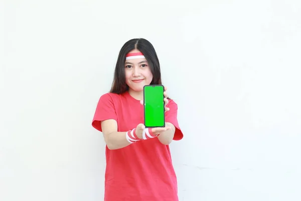 インドネシアの独立記念日を祝う赤い衣装を着た美しいアジアの女性の肖像画は 白い背景に隔離された携帯電話を保持するジェスチャーによって — ストック写真