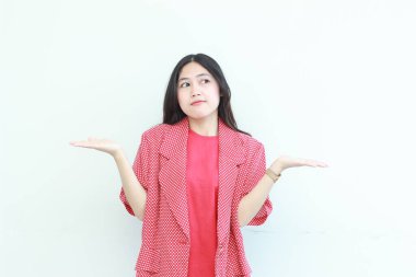 Asyalı güzel bir kadının portresi. Kırmızı giysisi ve beyaz arka planda izole edilmiş kafası karışık bir jesti..