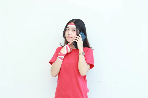 身穿红色服装的美丽的亚洲女人的肖像 在庆祝印度尼西亚独立日的同时 带着与白色背景隔离的沉思表情打电话来 — 图库照片