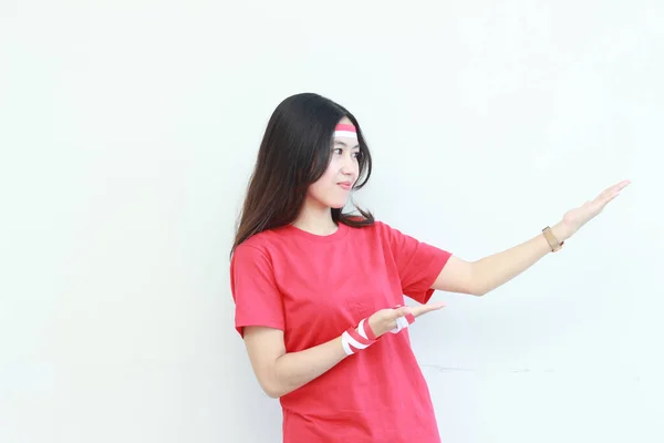 インドネシア独立記念日を祝う赤い衣装を着た美しいアジアの女性の肖像画は 白い背景に隔離されたコピースペースの側を指しています — ストック写真