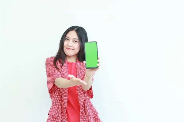 白い背景に隔離された携帯電話と笑顔を保持する赤い服を着ている美しいアジアの女性の肖像画 — ストック写真