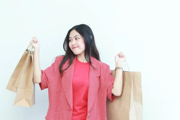 白い背景に隔離された幸せな表現の袋を運ぶ赤い衣装を身に着けている美しいアジアの女性の肖像画 — ストック写真