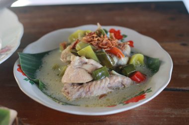 Bir kase Garang Asem, tipik bir Endonezya yemeği. İşlenmiş tavuk yemekleri muz yaprakları ve Hindistan cevizi sütüyle pişirilir, ekşi ve baharatlı tatların hakim olduğu..