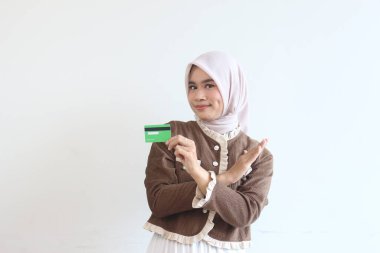 Başörtüsü takan şık genç bir kadın kredi kartı teklifini reddediyor. Finans ve akıllı harcamalar kavramı.