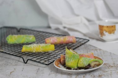 Krepleri yakın çekim mi yoksa gökkuşağı desenli Dadar Gulung mu servis edilmeye hazır? Yemek konsepti fotoğrafı. Endonezya geleneksel yemekleri.