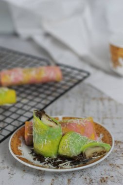 Krepleri yakın çekim mi yoksa gökkuşağı desenli Dadar Gulung mu servis edilmeye hazır? Yemek konsepti fotoğrafı. Endonezya geleneksel yemekleri.