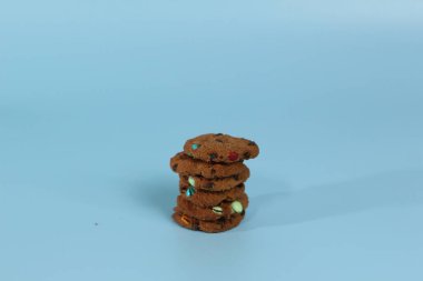 Parlak arka planda izole edilmiş gökkuşağı parçalı çikolatalı kurabiyeler. Yemek konsepti fotoğrafı.