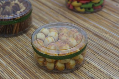 Tahta bir yüzeyde, temiz bir konteynırda, kastengel kurabiyelerinin yakın çekimi. Kurabiyeler altın sarısı ve lezzetli görünüyor..