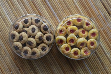 Endonezya kurabiyeleriyle dolu iki temiz kavanoz. Biri çikolatalı, diğeri kırmızı reçelli. Lezzetli ev yapımı hamur işleri.!