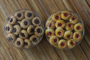 İçi çeşitli lezzetli kurabiyelerle dolu iki konteyner. Birinde çikolata, diğerinde reçel var..