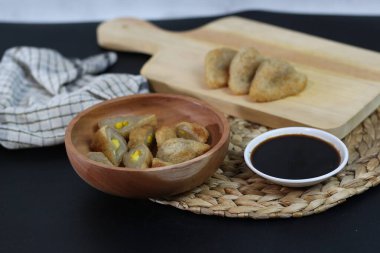 Geleneksel bir Endonezya balık keki olan Pempek 'in lezzetli bir tabağı, zengin ve koyu bir sosla servis ediliyor. Afiyet olsun!