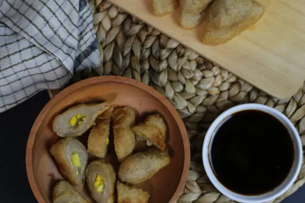 Popüler bir Endonezya balık keki olan Pempek 'in en iyi görüntüsü, koyu soslu ahşap bir kasede düzenlenmiş. Lezzetli bir aşçılık deneyimi..