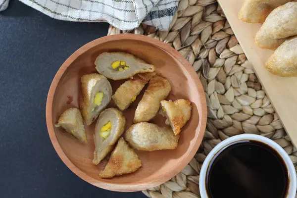 Bir tabak Pempek, popüler bir Endonezya atıştırmalığı, kara sosla servis ediliyor. Çıtır çıtır dış görünüş, yumuşak iç güzellikle çelişiyor..