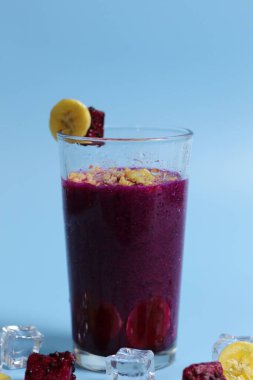 Muz ve kırmızı ejderha meyveli sağlıklı taze meyve suyu. Parlak arka planda izole edilmiş bardaklarda. sağlıklı diyet fotoğrafı konsepti.