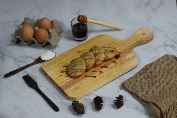Kırsal ahşap bir tahtanın üzerinde servis edilen nefis bir Serabi düzenlemesi. Bal, yumurta ve un eşliğinde harika bir aşçılık sahnesi..