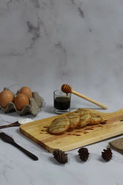 Geleneksel Endonezya krepi olan Serabi 'nin bal ve yumurtalarla servis edilen enfes bir görüntüsü. Mermer yüzeyde minimalist bir şekilde çekilmiş..