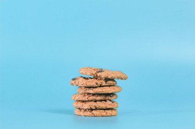 Mavi arka planda birkaç çikolatalı kurabiyenin yakın plan fotoğrafı..