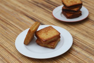 Beyaz tabaklar üzerinde geleneksel Endonezya kurabiyeleri olan Kue Kering 'in yakın plan fotoğrafı. Altın sarısı ve iştah açıcı.