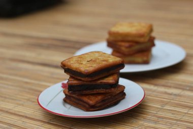 Tahta bir masanın üzerinde iki yığın çikolatalı sandviç krakeri..
